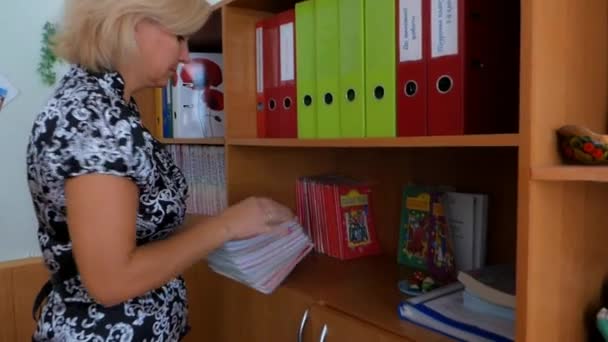 Lehrer faltet die Schulbücher — Stockvideo