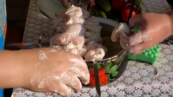 Female hand strung pieces of meat on skewers — Stock Video