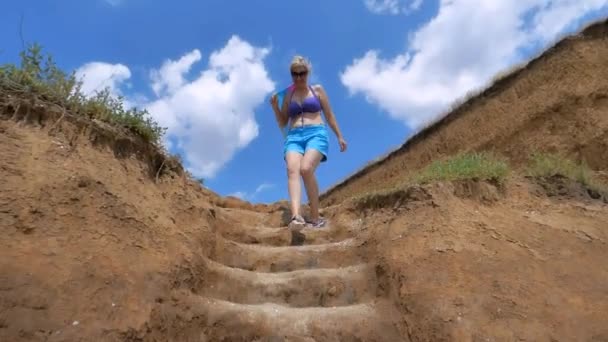 Uma mulher desce as escadas — Vídeo de Stock
