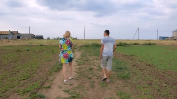 Man en vrouw die langs de weg lopen — Stockvideo