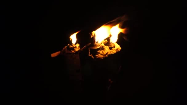 Три горящих факела вдоль пляжа в океане. Факелы в тропиках на отдыхе — стоковое видео