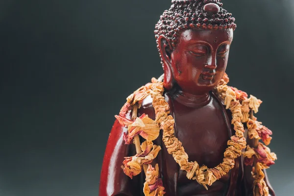 Estatua de Buda en ofrendas de flores. Estatua funeraria de Buda Shakyamuni decorada con coronas de flores — Foto de Stock