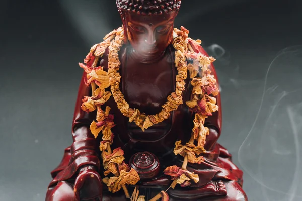 Estatua de Buda en ofrendas de flores. Estatua funeraria de Buda Shakyamuni decorada con coronas de flores — Foto de Stock