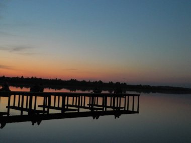 iskelede, günbatımının arka planında