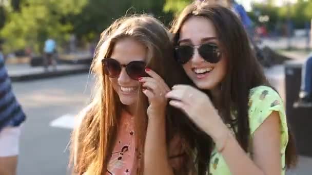 Dos hermosas chicas de moda se ríen al aire libre — Vídeo de stock