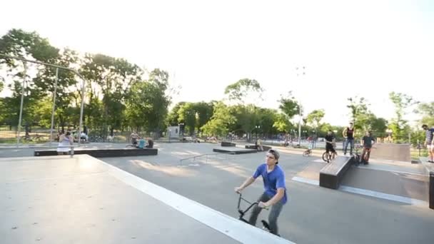 BMX райдер делает различные трюки во время езды в скейтпарке — стоковое видео