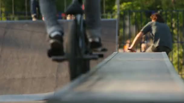 BMX pilota fa vari trucchi durante la guida in skatepark — Video Stock