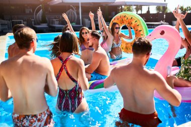 Çok ırklı bir arkadaş grubu özel bir villa havuzunda parti veriyor. Güneşli bir günde mayo giyen, şişme flamingo, kuğu ve yüzme havuzunda dans eden mutlu gençler..