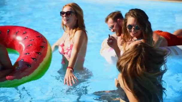 Os amigos têm a dança da festa da piscina com colchão inflável, brinquedos flutuantes da melancia. Mulheres bonitas quentes atraentes em biquíni e óculos de sol se divertem relaxando, relaxando no dia ensolarado de verão. Movimento lento. — Vídeo de Stock