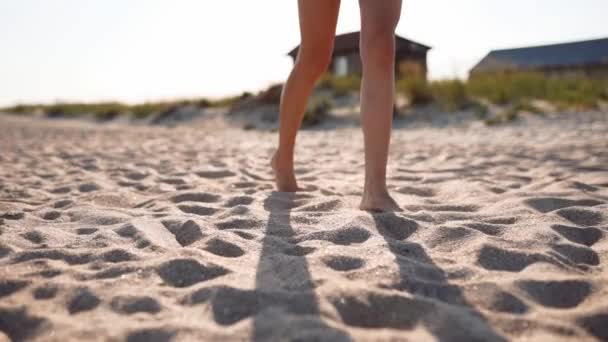 Vista da vicino di abbronzato gambe donna e piedi a piedi sulla spiaggia di sabbia al mare nella giornata di sole. Slim bella ragazza va al mare sulla sabbia bianca chiara. Femmina in vacanza. Angolo telecamera basso, rallentatore . — Video Stock