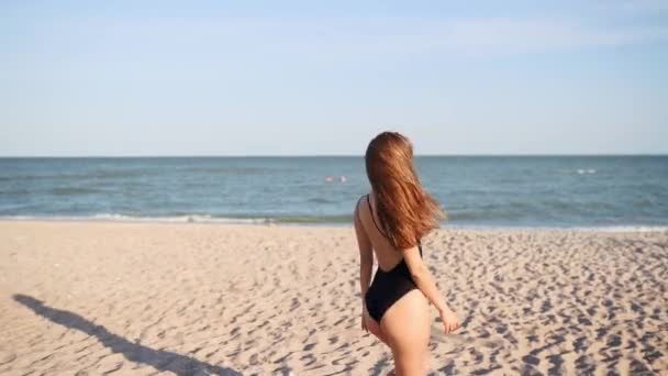 Pov volgt me met een foto van een mooie vrouw die haar vriendje naar de zee leidt. Speels aantrekkelijk meisje in badpak en zonnebril draait naar de camera en belt om haar te vergezellen. Langzame beweging. — Stockvideo