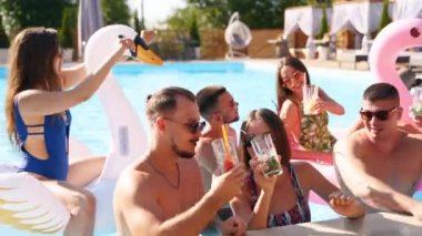 Arkadaşların tatil köşkünde havuzda kokteyllerle kadeh kaldırıyor. Mayo giymiş mutlu gençler dans ediyor, şişme flamingo ve kuğuyla klüplere gidiyor, güneşli bir günde tatil köyünde. Tıkırdayan bardaklar.