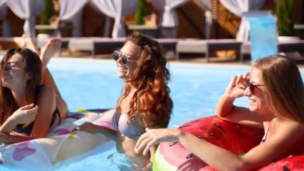 Schöne heiße hübsche Mädchen im Bikini haben Pool-Party mit aufblasbarer Wassermelone schwimmende Matratze tanzen. Glamouröse Frauen in Badebekleidung und Sonnenbrille haben an sonnigen Sommertagen ihren Spaß. Zeitlupe — Stockvideo