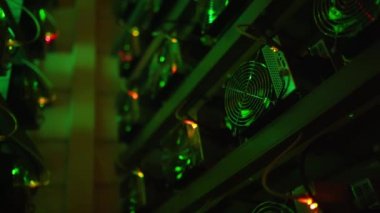 Bitcoin madencileri büyük çiftlikte. Kürsüdeki ASIC madencilik ekipmanları çelik konteynırdaki kripto para birimini rafa kaldırıyor. Entegre devre veri tabanında engelleme zinciri uygulaması. Sunucu odası ışıkları.