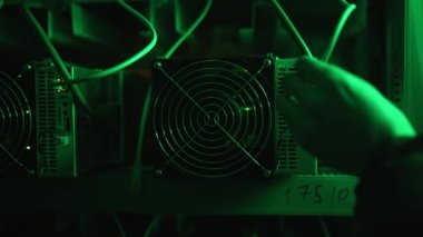 Kripto para çiftliğindeki Bitcoin madencilik ekipman servisi. Teknisyen veri tabanında ASIC madencileri soketine rj-45 ethernet kablo bağlayıcı takıyor. Engelleme zinciri donanım donanımı kurulum görüntüleri.