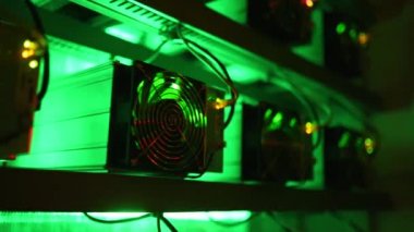 Bitcoin madencileri büyük çiftlikte. Kürsüdeki ASIC madencilik ekipmanları çelik konteynırdaki kripto para birimini rafa kaldırıyor. Engelleme teknolojisi. Güç kaynağı vantilatörleri ve ızgaralar. Sunucu odası ışıkları.