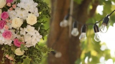 Ampuller, çelenkler ve çiçek kompozisyonu. Tatil süsü olarak ağaçta asılı duran elektrik lambaları.