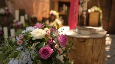 Pembe ve beyaz güllerin güzel çiçek kompozisyonu ile kırsal tarzda bir düğün dekoru. Yüzükler kütüğün üzerinde 