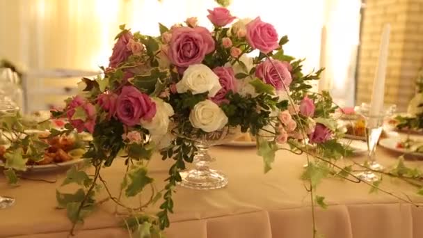 Bruiloft tafel rustieke stijl decor met gerechten, drankjes en bloemen in roze en beige kleuren. Floristische composities van rozen op feestbanket eettafel. — Stockvideo