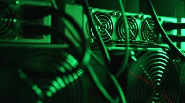 Bitcoin madencileri büyük çiftlikte. Kürsüdeki ASIC madencilik ekipmanları çelik konteynırdaki kripto para birimini rafa kaldırıyor. Entegre devre veri tabanında engelleme zinciri uygulaması. Sunucu odası ışıkları.