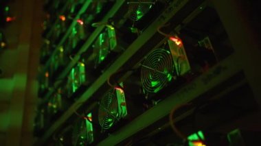 Bitcoin madencileri büyük çiftlikte. Kürsüdeki ASIC madencilik ekipmanları çelik konteynırdaki kripto para birimini rafa kaldırıyor. Entegre devre veri tabanında engelleme zinciri uygulaması. Sunucu odası ışıkları.