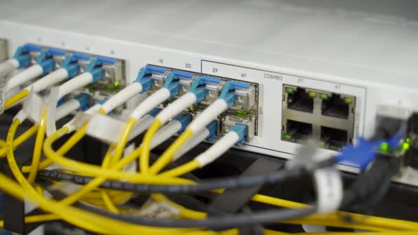 Optischer Server und Router im Serverraum des Rechenzentrums. Netzwerkgeräte blinken mit Lichtern auf dem Gepäckträger. Glasfaserkabel, die mit Ports verbunden sind. Schnelles Internet.