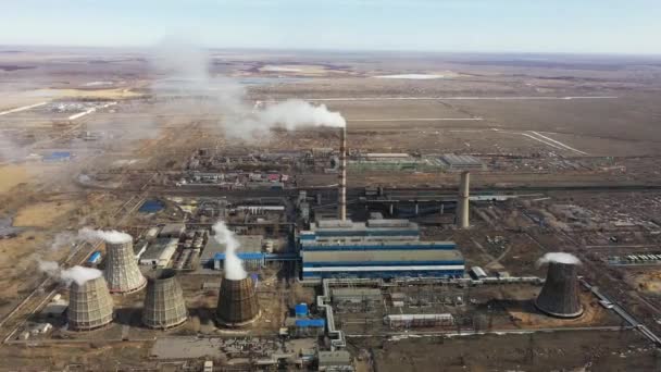 Vista aérea da central térmica. O drone voa sobre os tubos de fumaça da chaminé e as torres de refrigeração da área industrial no por do sol. Estação térmica de geração de eletricidade de cima esgota as emissões atmosféricas. — Vídeo de Stock