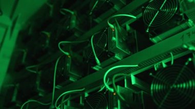 Bitcoin madencileri büyük çiftlikte. Kürsüdeki ASIC madencilik ekipmanları çelik konteynırdaki kripto para birimini rafa kaldırıyor. Entegre devre veri tabanında engelleme zinciri uygulaması. Sunucu odası ışıkları.