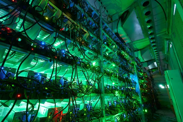 Bitcoin-Miner in einer großen Farm. ASIC-Bergbaugeräte auf Standbrettern fördern Kryptowährungen in Stahlcontainern. Blockchain-Technologie anwendungsspezifisches integriertes Schaltungsrechenzentrum. Serverraumbeleuchtung. — Stockfoto