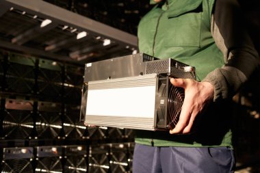 Mover, Bitcoin ASIC madencisini depoda tutuyor. ASIC madencilik ekipmanlı işçiler çelik konteynırda kripto para çıkarmak için tezgahta bekliyor. Uygulama özel entegre devre madencileri depolama.