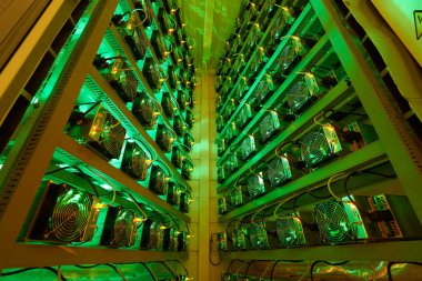 Bitcoin madencileri büyük çiftlikte. Kürsüdeki ASIC madencilik ekipmanları çelik konteynırdaki kripto para birimini rafa kaldırıyor. Entegre devre veri tabanında engelleme zinciri uygulaması. Sunucu odası ışıkları.