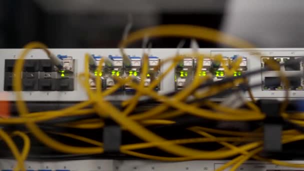 Optischer Server und Router im Serverraum des Rechenzentrums. Netzwerkgeräte blinken mit Lichtern auf dem Gepäckträger. Glasfaserkabel, die mit Ports verbunden sind. Schnelles Internet. — Stockvideo