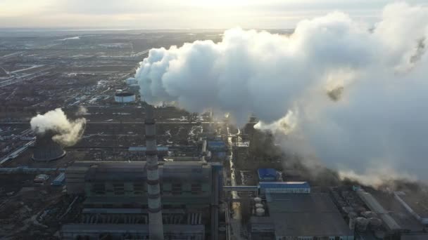 Luchtfoto van de thermische centrale. Drone vliegt over schoorsteen rookpijpen en koeltorens van industrieel gebied bij zonsondergang. Thermische elektriciteitscentrale van bovenaf zuigt de luchtemissies uit. — Stockvideo