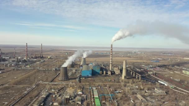 Vista aérea da central térmica. O drone voa sobre os tubos de fumaça da chaminé e as torres de refrigeração da área industrial no por do sol. Estação térmica de geração de eletricidade de cima esgota as emissões atmosféricas. — Vídeo de Stock