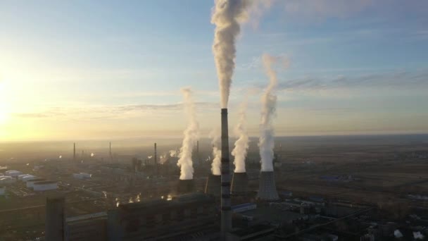 Vista aérea da central térmica. O drone voa sobre os tubos de fumaça da chaminé e as torres de refrigeração da área industrial no por do sol. Estação térmica de geração de eletricidade de cima esgota as emissões atmosféricas. — Vídeo de Stock