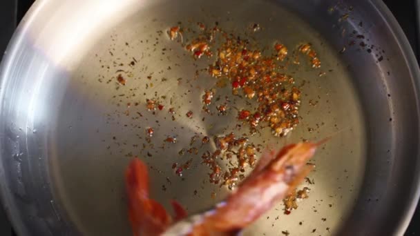 Ο μάγειρας ψήνει γαρίδες. Κοντινό πλάνο του βασιλιά γαρίδες τηγάνισμα σε ένα τηγάνι. Ο σεφ τηγανίζει βασιλικές γαρίδες σε καυτό τηγάνι. Προετοιμασία μακρο-θαλασσινών τροφίμων. — Αρχείο Βίντεο