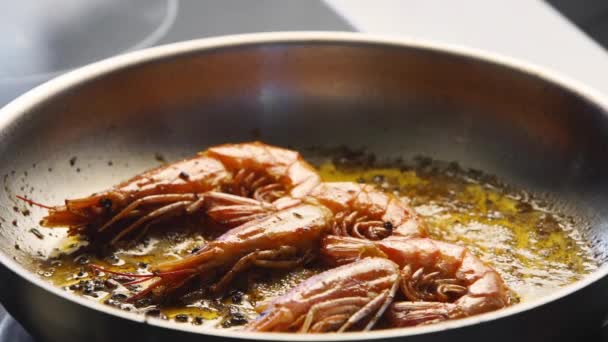 Cocine vierte los camarones en una parrilla con salsa de cucharón. Primer plano de langostinos fritos en una sartén. Chef freír camarones reales en una sartén caliente. Preparación de alimentos de mar macro. — Vídeo de stock