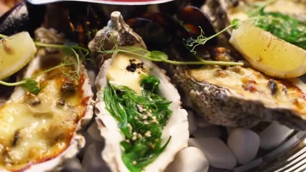 Ensemble de fruits de mer cuisinés, crevettes, crevettes royales, moules, huîtres et calmars sont servis dans une grande assiette de salver pour les visiteurs du restaurant de luxe. Plat méditarien traditionnel tournant sur un plateau. — Video