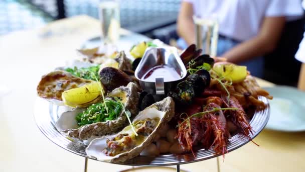 Kokt blandad skaldjursset salver, hummerräkor, kungsräkor, musslor, ostron och bläckfisk serveras på ett bord för lyxiga restaurangbesökare. Traditionell meditarisk rätt på bricka. — Stockvideo