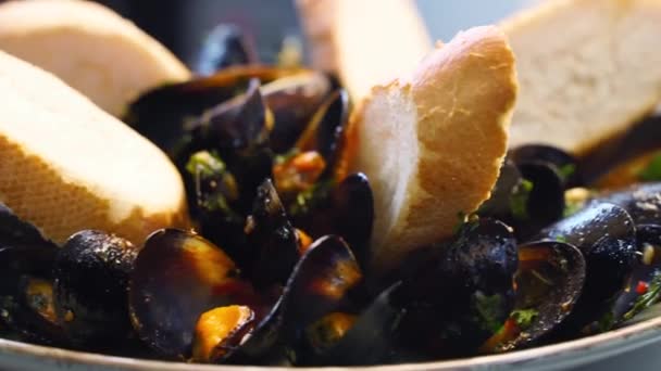 Cuisson de délicieuses moules fraîches sont servis sur une grande assiette de salver pour les visiteurs du restaurant de luxe. Plat méditarien traditionnel tournant sur un plateau. Mouvement lent. — Video