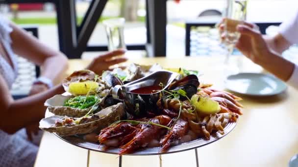 Μίγμα salver θαλασσινά, αστακός γαρίδες, γαρίδες βασιλιά, μύδια, στρείδια και καλαμάρια σερβίρονται για τους επισκέπτες πολυτελή εστιατόριο clinking ποτήρια με κρασί και επευφημίες. Παραδοσιακό πιάτο διαλογισμού στο δίσκο. — Αρχείο Βίντεο