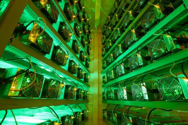 Bitcoin madencileri büyük çiftlikte. Kürsüdeki ASIC madencilik ekipmanları çelik konteynırdaki kripto para birimini rafa kaldırıyor. Entegre devre veri tabanında engelleme zinciri uygulaması. Sunucu odası ışıkları.