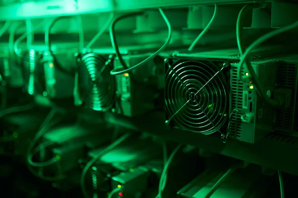 Bitcoin-Miner in einer großen Farm. ASIC-Bergbaugeräte auf Standbrettern fördern Kryptowährungen in Stahlcontainern. Blockchain-Technologie anwendungsspezifisches integriertes Schaltungsrechenzentrum. Serverraumbeleuchtung. — Stockfoto