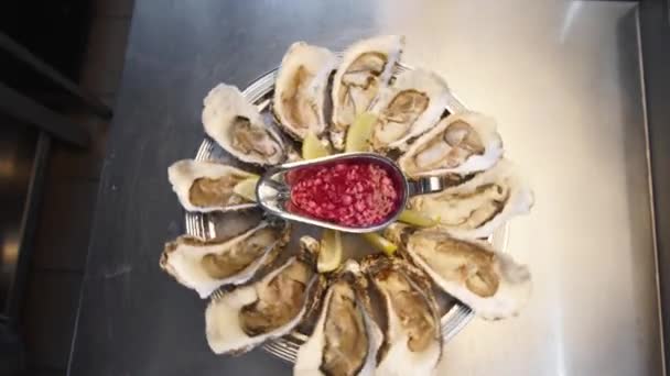 Vassoio di ostriche fresche servite sul ghiaccio con limone che ruota su un grande piatto di salver per i visitatori del ristorante di lusso. Piatto tradizionale meditariano set di frutti di mare per buongustai. — Video Stock