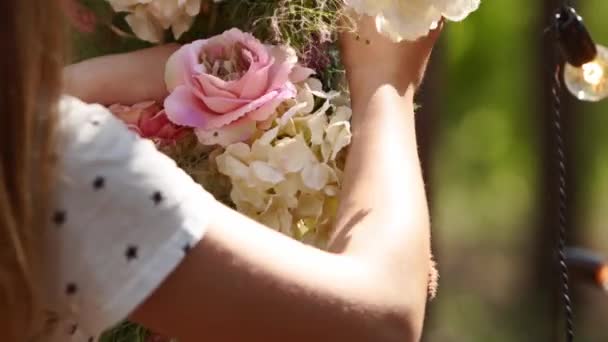 Γαμήλια διακόσμηση ρύθμιση σε παστέλ ξεθωριασμένα χρώματα σε πευκοδάσος. Ανθοπωλεία και διακοσμητές χέρια κάνοντας ρουστίκ ή boho floral μπουκέτο με τριαντάφυλλα συνθέσεις λουλουδιών, ξύλο, πάμπας γρασίδι, κεριά. — Αρχείο Βίντεο
