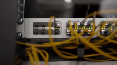 Veri merkezi sunucu odasının optik sunucusu ve yönlendiricisi. Ağ ekipmanları ışıklarla yanıp sönüyor. Optik fiber kablolar bağlantı noktalarına bağlı. Yüksek hızlı İnternet.