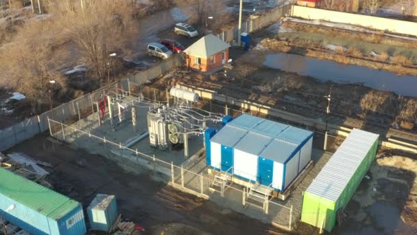 Luchtfoto over vermogenstransformator met kabels op elektrisch verdelend onderstation op zonnige dag. Actieve koelventilator op moderne transformator. Hoogspanningsleiding op isolatoren. — Stockvideo