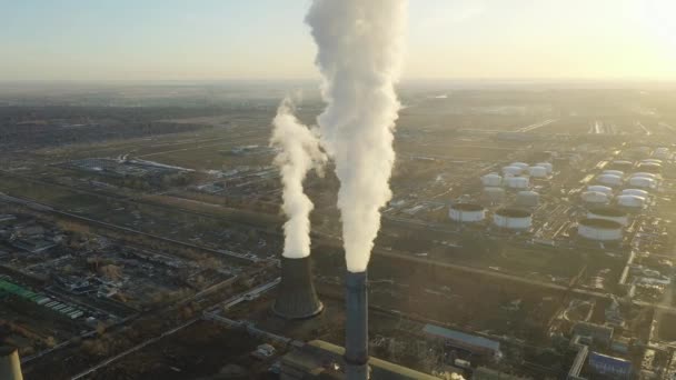 Luchtfoto van de thermische centrale. Drone vliegt over schoorsteen rookpijpen en koeltorens van industrieel gebied bij zonsondergang. Thermische elektriciteitscentrale van bovenaf zuigt de luchtemissies uit. — Stockvideo