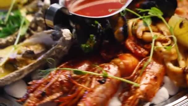 Ensemble de fruits de mer cuisinés, crevettes, crevettes royales, moules, huîtres et calmars sont servis dans une grande assiette de salver pour les visiteurs du restaurant de luxe. Plat méditarien traditionnel tournant sur un plateau. — Video