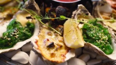 Lüks restoran ziyaretçileri için büyük bir tabakta pişirilmiş deniz ürünleri seti, ıstakoz karidesi, kral karidesi, midye, istiridye ve mürekkep balığı servis edilir. Bir tepside dönen geleneksel meditaryen yemek.